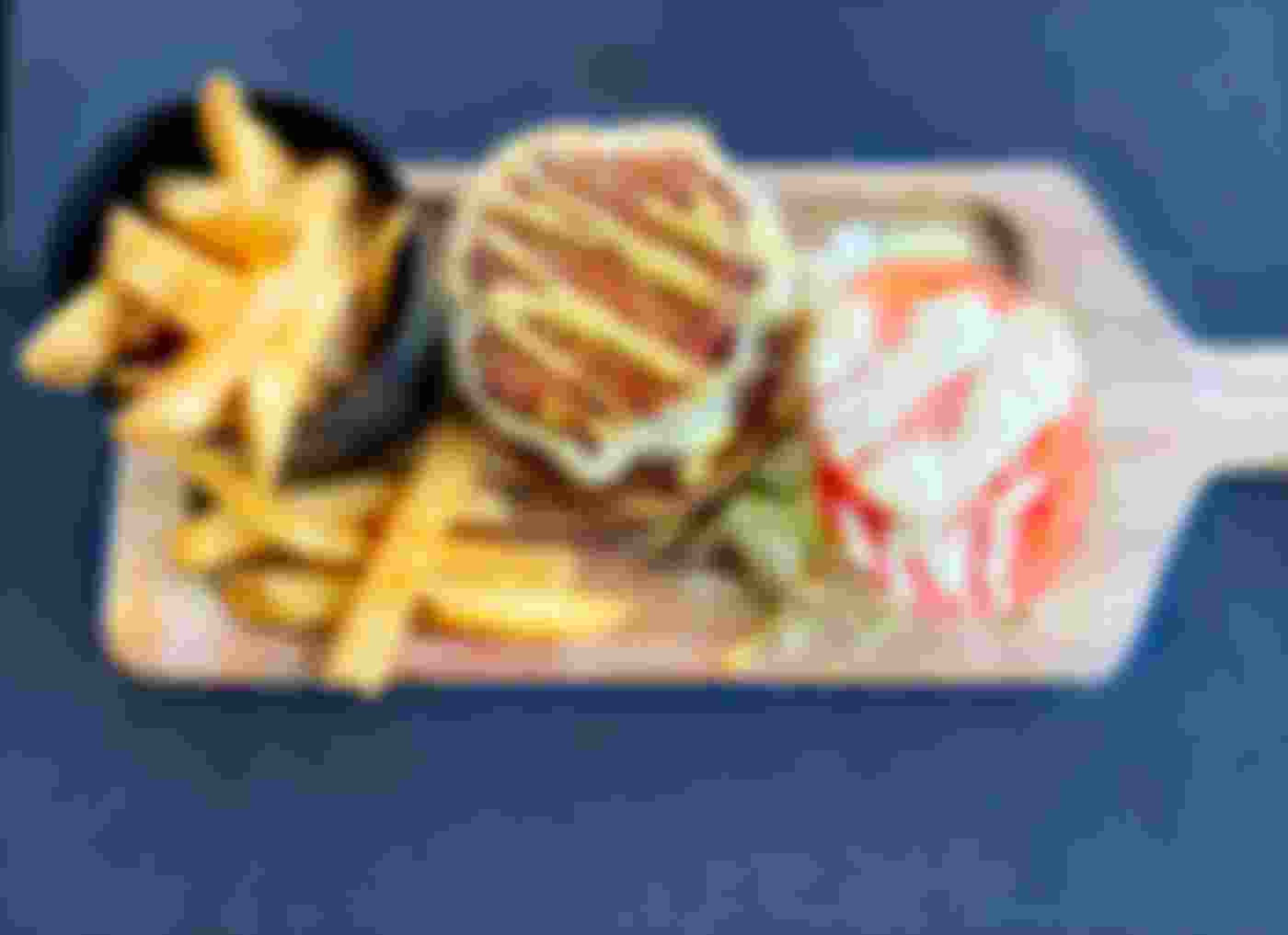 burger and fries meal on wooden board